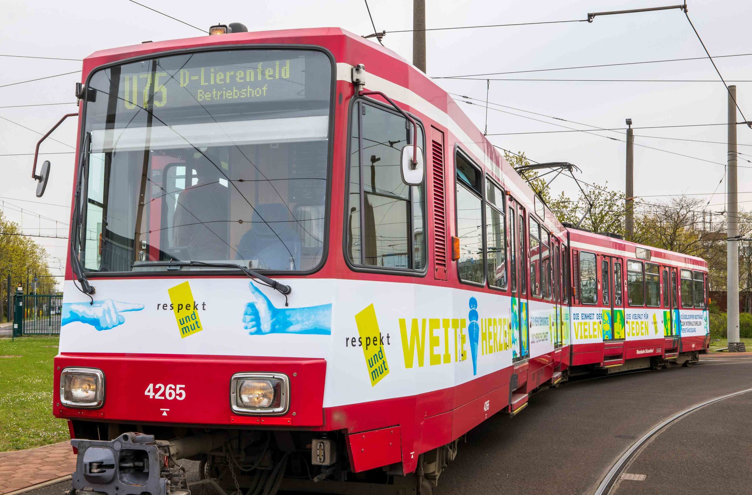 Eine neu gestaltete Bahn rollt für Respekt und Mut durch Düsseldorf und wirbt für mehr Gerechtigkeit und Menschlichkeit. Auf ihr zu lesen sind die Mottos „Weite Herzen“ sowie „Die Einheit der Vielen – die Vielfalt für Jeden“. Foto: Rheinbahn